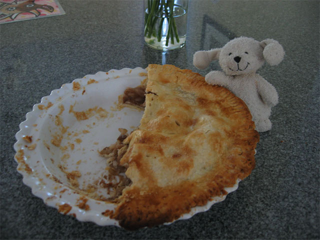 Mickey, the stuffed dog, next to a half-eaten apple pie.