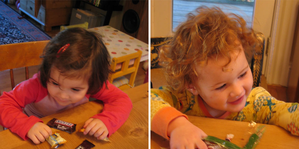 two toddler girls leaning on a wooden table