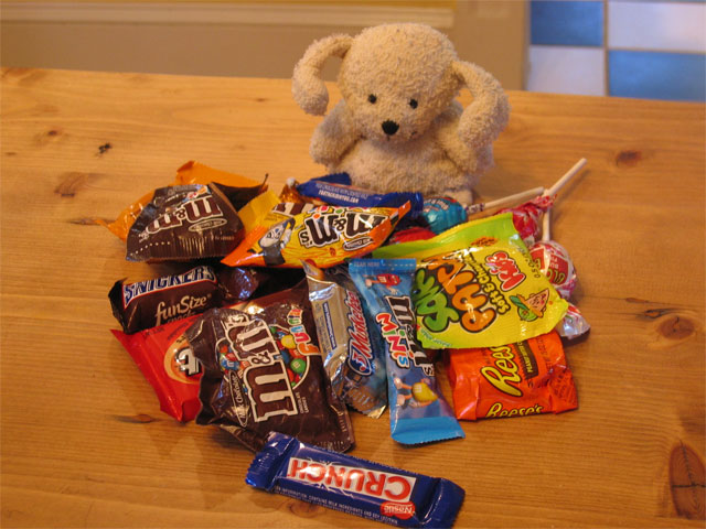 small stuffed animal dog with a pile of Halloween candy