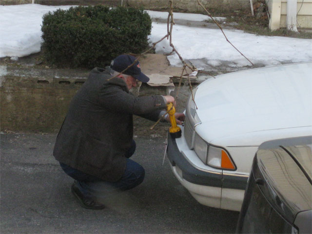 man repairing car bumper